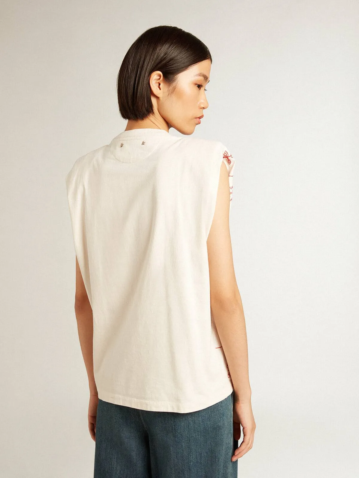 T-shirt senza maniche di colore bianco vissuto con ricamo rosso sul davanti